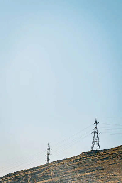 Två Elektriska Torn Toppen Ett Berg Molnfri Blå Himmel — Stockfoto
