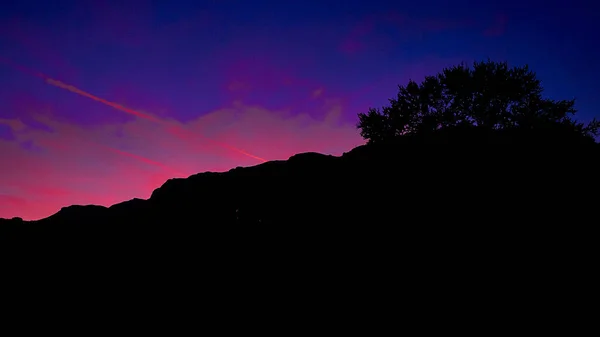 夕日の空を背景に山のシルエットの美しいショット — ストック写真