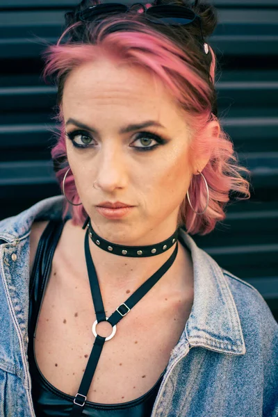 ピンクの髪をしたクールな白い女性の垂直ショット ゴシックスタイルのメイク アクセサリー — ストック写真
