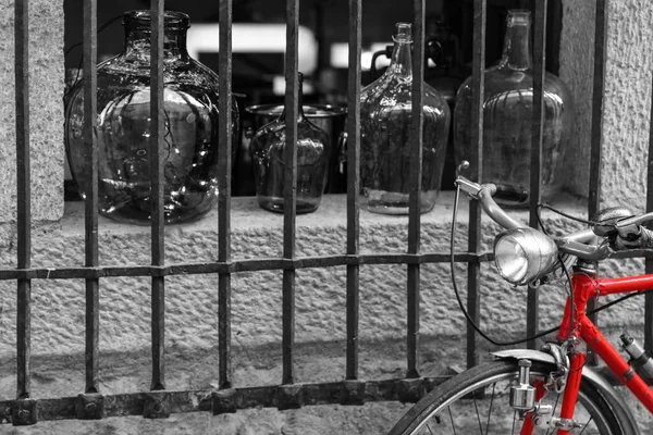 淡淡的红色带有灰度成分的空玻璃瓶的自行车的选择性的红色镜头 — 图库照片