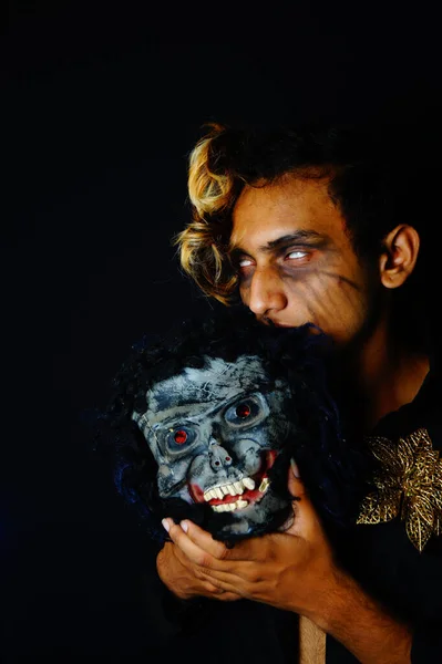 恐ろしいマスクを保持している南アジアの男性のクローズアップショット — ストック写真
