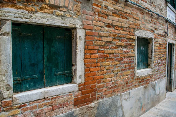 木造の窓が閉じられた古いレンガ造りの建物のファサード — ストック写真