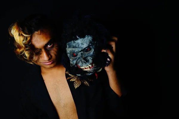 恐ろしいマスクを保持している南アジアの男性のクローズアップショット — ストック写真