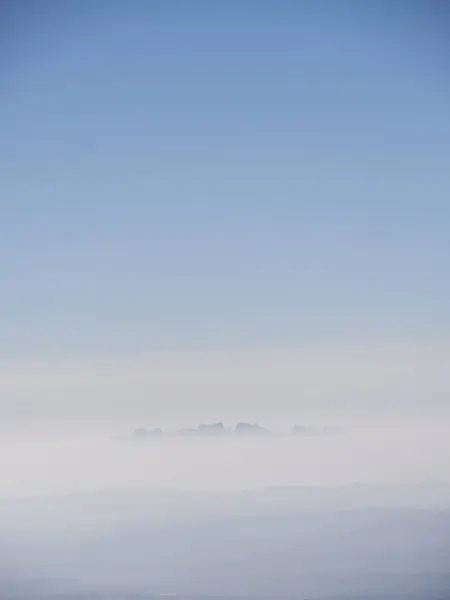 遠くの丘の垂直方向のショット 青の背景 — ストック写真