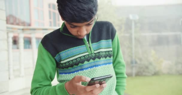 Sydasiatisk Pojke Med Telefon — Stockvideo