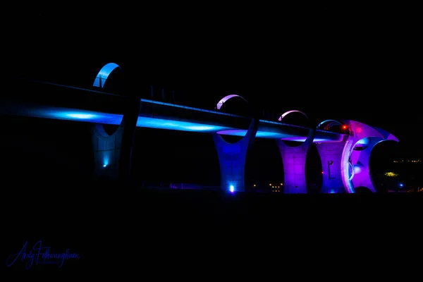未来的な紫と青のネオンライトでサポートしています色の橋とクロコダイルの高い橋 — ストック写真