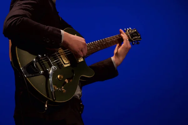 Ein Mann Spielt Gitarre Auf Blauem Hintergrund — Stockfoto