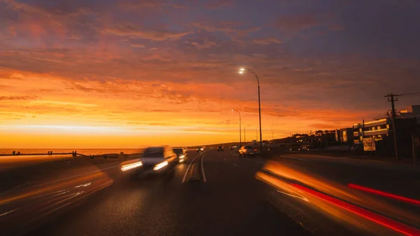 夕暮れ時の曇り空に向かって車を走らせる交通路 — ストック写真