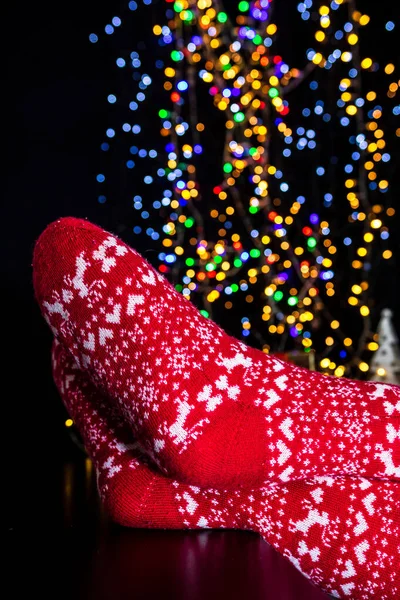 Närbild Kvinnliga Fötter Röda Julstrumpor Med Bokeh Ljus Bakgrund — Stockfoto