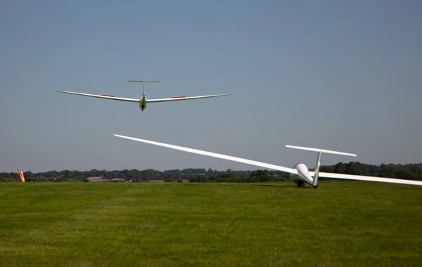 Δύο Λευκά Αεροπλάνα Πετούν Πάνω Από Μια Πράσινη Περιοχή — Φωτογραφία Αρχείου