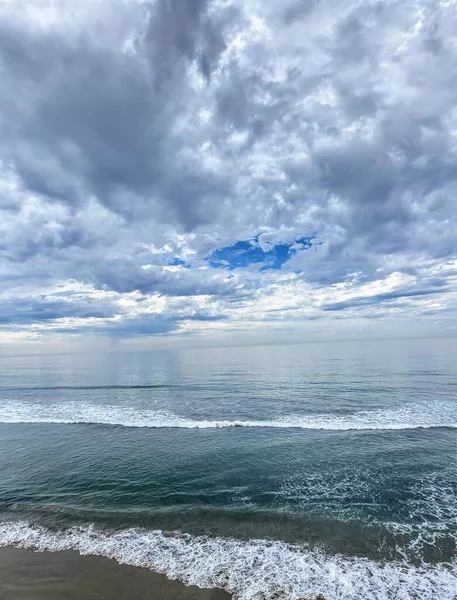青い空の下で穏やかな泡の波を持つ美しい海の垂直ショット — ストック写真