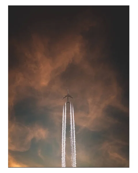 日落时在云天中飞行的飞机 — 图库照片