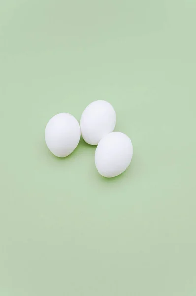 白と緑の表面に白い有機卵とテキスト用のコピースペースがあります — ストック写真