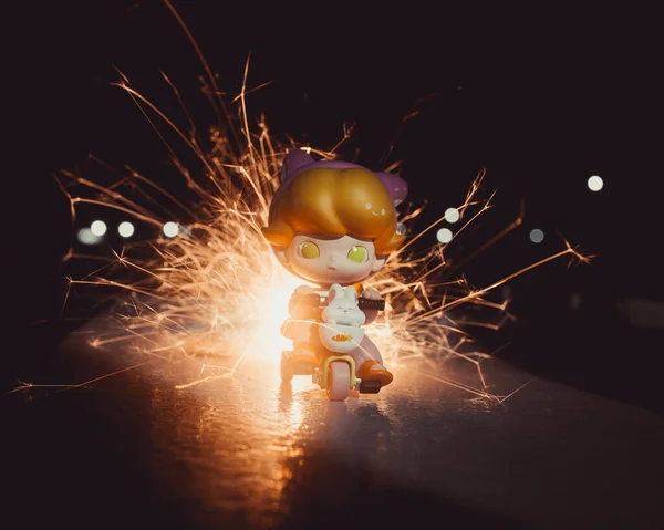 後ろに明るい火花とボケが灯る三輪車のおもちゃの少年キャラクター — ストック写真