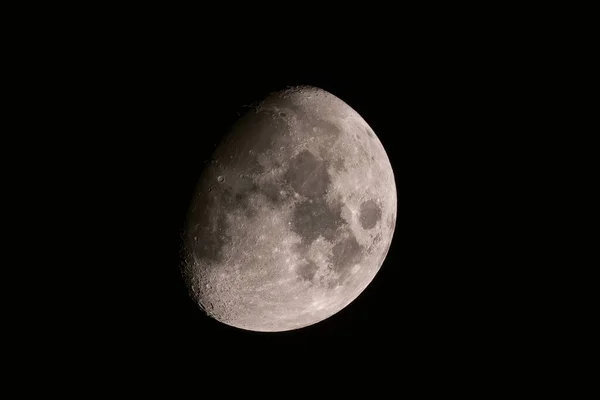 在漆黑的天空中 在灰暗的半月形卫星上拍摄到了一些细节 — 图库照片