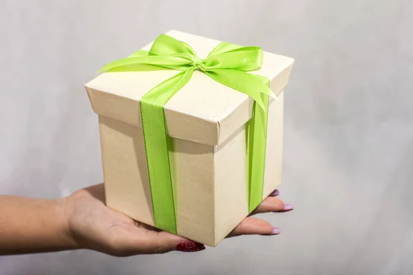 Γυναικείο Χέρι Κρατώντας Πράσινο Και Κίτρινο Κουτί Δώρου Φιόγκο Λευκό — Φωτογραφία Αρχείου