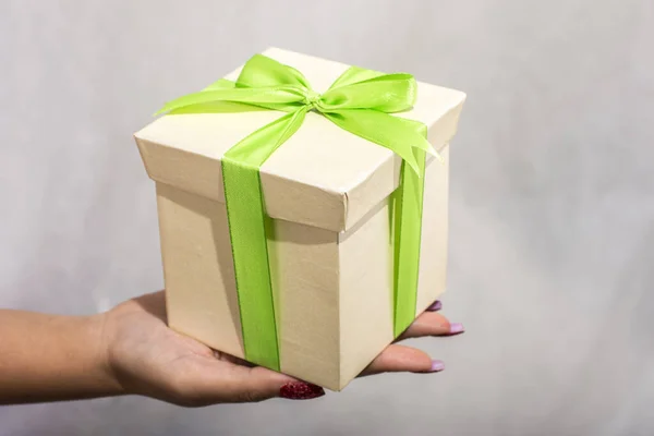 Female Hand Holding Green Yellow Gift Box Bow White Background Royalty Free Stock Photos