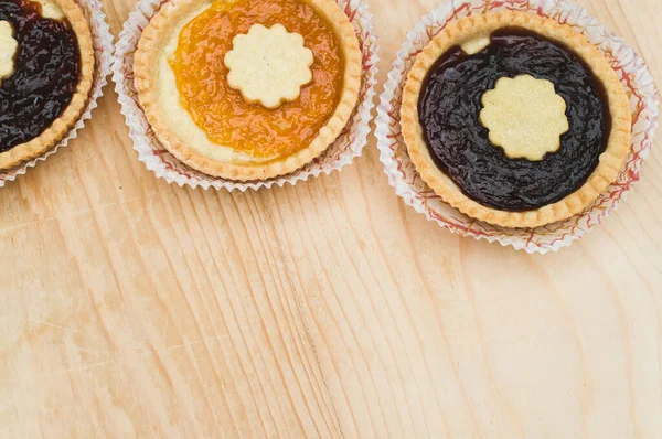 Geïsoleerde Abrikozen Kersenjam Taart Een Papieren Beker Een Houten Tafelblad — Stockfoto