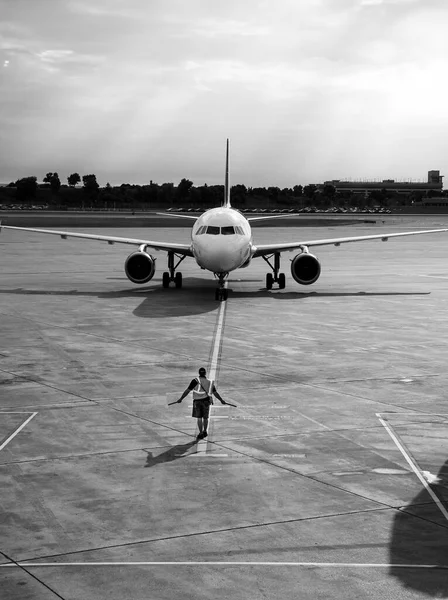 Eine Graustufenaufnahme Eines Rampenagenten Der Das Anfliegende Flugzeug Auf Dem — Stockfoto