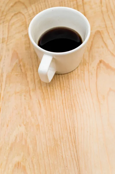 在粗糙的木制背景上的白色杯子里放着黑咖啡 里面有文字 — 图库照片