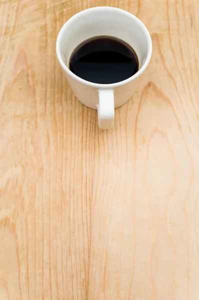 在粗糙的木制背景上的白色杯子里放着黑咖啡 里面有文字 — 图库照片