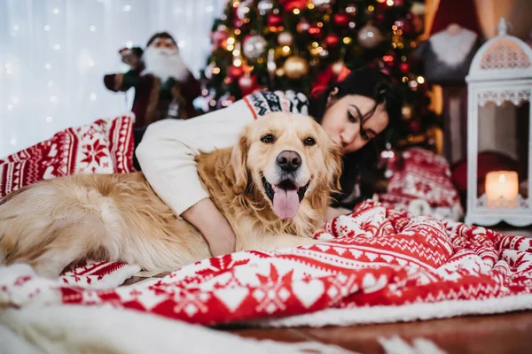 Женщина Играет Своей Золотистой Собакой Ретривером Рядом Красочной Рождественской Ёлкой — стоковое фото