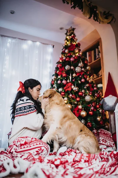 Samica Bawiąca Się Swoim Psem Golden Retriever Obok Kolorowego Choinki — Zdjęcie stockowe