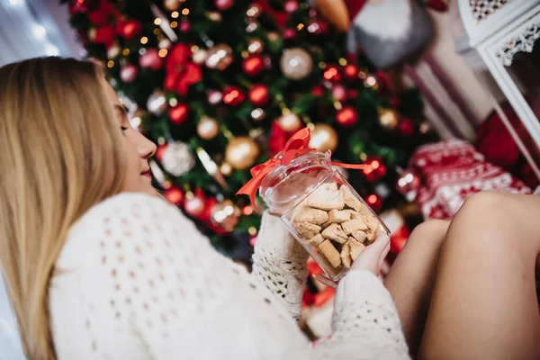 Een Jonge Vrouw Met Een Koekjestrommel Cadeau Met Kleurrijke Kerstboom — Stockfoto