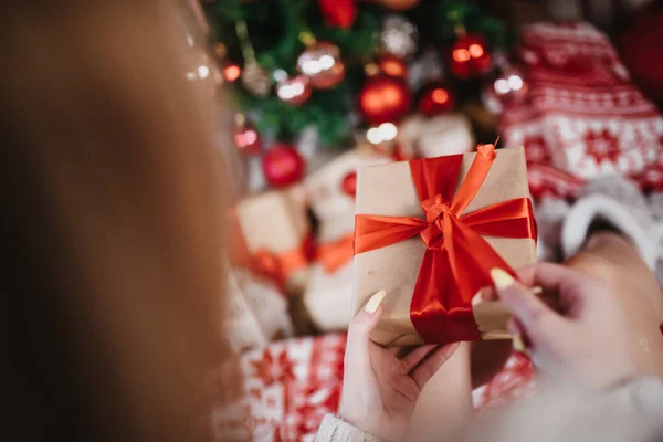 Egy Fiatal Kezében Egy Ajándék Színes Karácsonyfa Háttérben Karácsony Este — Stock Fotó