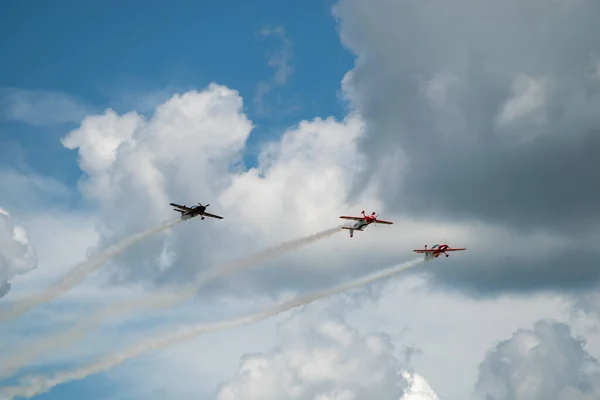 航空ショー中に曇った空に対して飛行する航空機のグループ — ストック写真