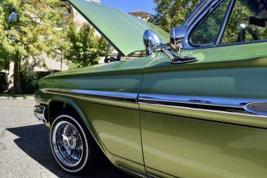 FRESNO, UNITED STATES - Oct 09, 2021: A Closeup of a Classic Glitter Custom Green IMPALA car clipart