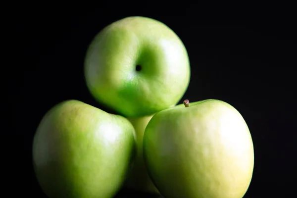 Eine Nahaufnahme Von Aufgetürmten Grünen Äpfeln Isoliert Auf Dunklem Hintergrund — Stockfoto
