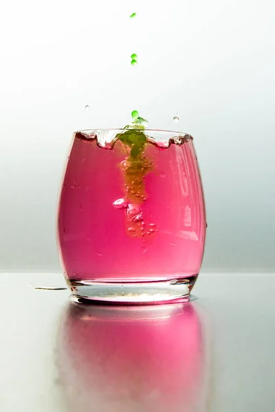 Een Verticaal Shot Van Een Glas Roze Water Met Spatten — Stockfoto