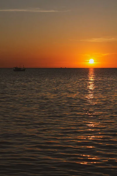 Eine Vertikale Aufnahme Des Meeres Unter Einem Orangefarbenen Sonnenuntergang — Stockfoto