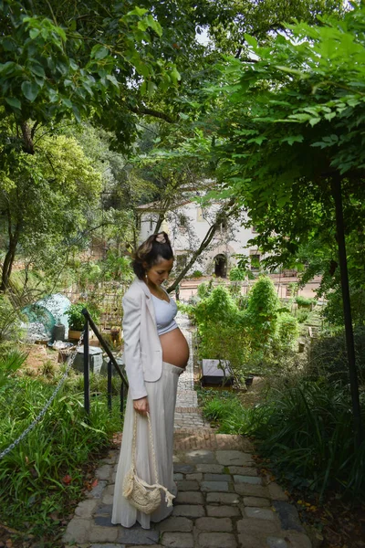 一个漂亮的年轻孕妇站在公园里的画像 — 图库照片