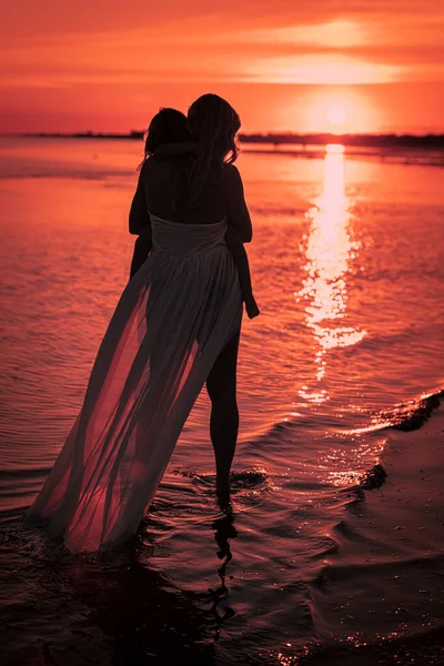 Вертикальний Знімок Жінки Тримає Дитину Захоплюючому Морському Заході Сонця — стокове фото