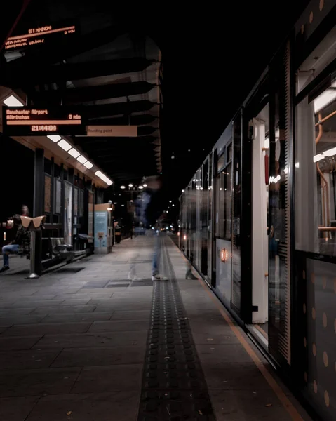 Eine Vertikale Aufnahme Der Bahn Mit Menschen Silhouetten Bewegungseffekt — Stockfoto