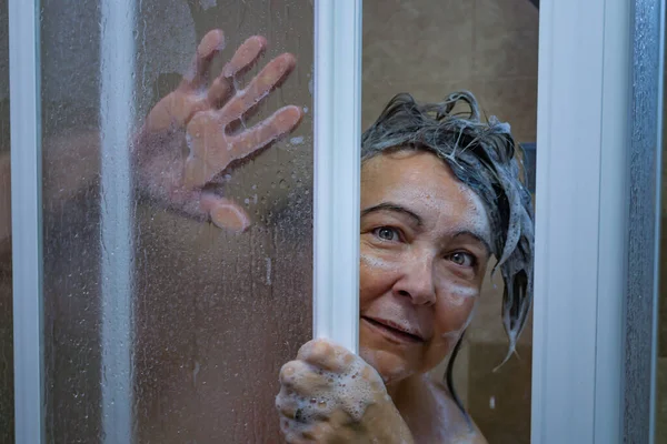 여자가 문밖을 비누칠하며 비누를 채놀라는 — 스톡 사진