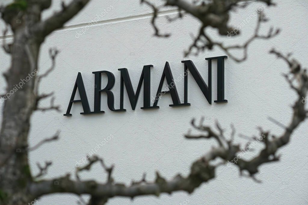 MAASMECHELEN, BELGIUM - Nov 01, 2021: Armani trademark sign, through a tree at Maasmechelen village outlet store in Belgium