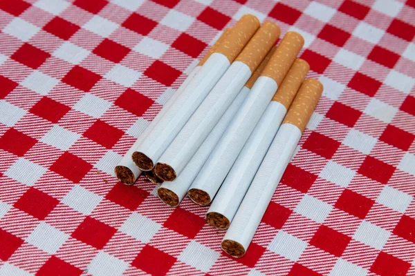 Egy Közelkép Egy Halom Cigarettáról Egy Piros Fehér Kockás Asztalterítőn — Stock Fotó