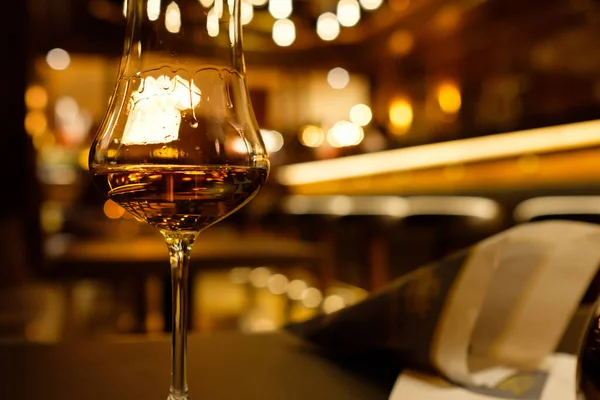 背景がぼんやりとしたバーにあるウイスキーのグラス — ストック写真