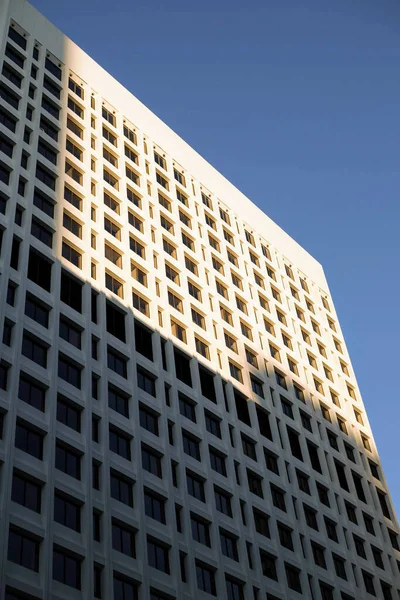 Μια Κάθετη Χαμηλή Γωνία Ενός Ψηλού Κτιρίου Μισοσκεπασμένο Από Σκιά — Φωτογραφία Αρχείου