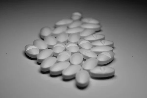 Egy Szürkeárnyalatos Közelkép Sok Gyógyszerről Egy Fehér Asztalon — Stock Fotó