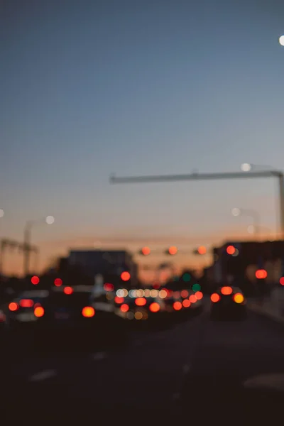 夕暮れ時の街の賑やかな通りの信号のぼやけたシルエット — ストック写真