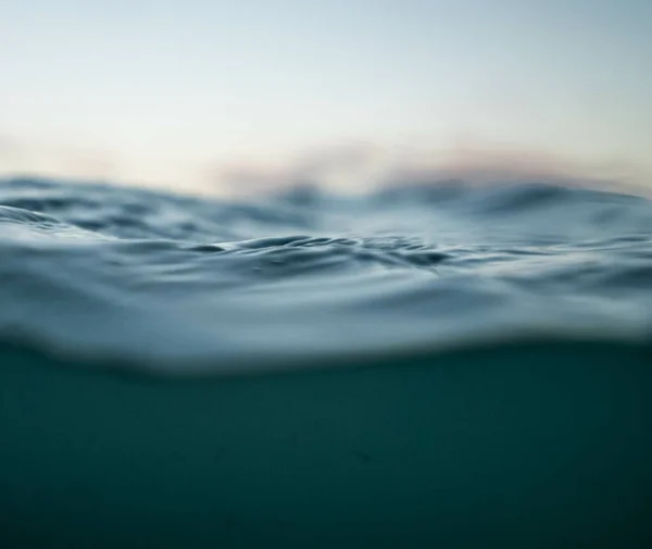 背景がぼやけた太陽の下での海の波の選択的なショット — ストック写真
