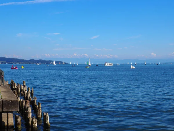 View Lake Sailing Boats Beach Wooden Posts Blue Background —  Fotos de Stock