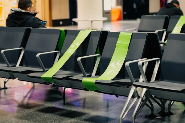 两个身份不明的男子坐在那里等待机场的到来 机场的椅子 上面有社交场合的醒目标志 验尸官 — 图库照片