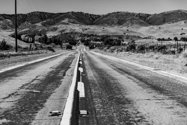 Grayscale Shot Asphalt Road Background Hills Clear Sky — Fotografia de Stock