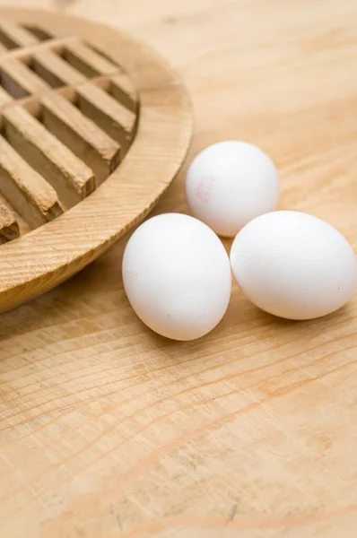 テキストのためのコピースペースを持つ天然の木製の卓上表面上の有機的な白い卵 — ストック写真