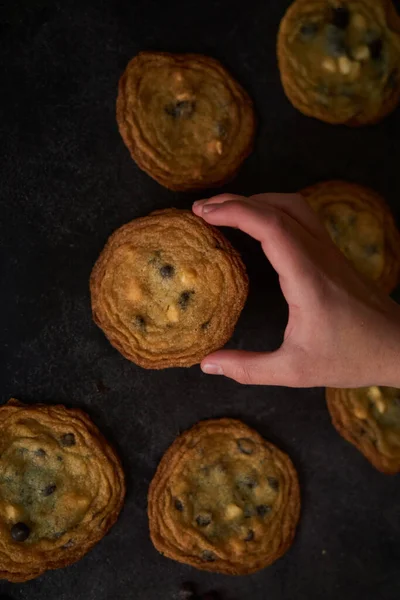Vertical Closeup Shot Hand Taking One Chocolate Chips Cookies Black — Stock Photo, Image